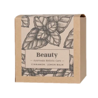 Opakowanie herbaty Teministeriet Ayurveda Beauty Organic o wadze 100g, na białym tle. Ziołowa mieszanka zawierająca cynamon i melisę, zapakowana w ekologiczne kartonowe opakowanie z minimalistycznym wzorem liści