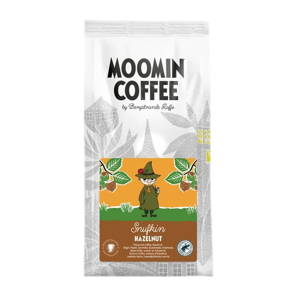Opakowanie kawy Moomin Coffee Snufkin Hazelnut 250g z postacią Snufkina na etykiecie, otoczoną orzechami laskowymi na tle w stylu Moominów. Kawa smakowa z dodatkiem orzechów laskowych.