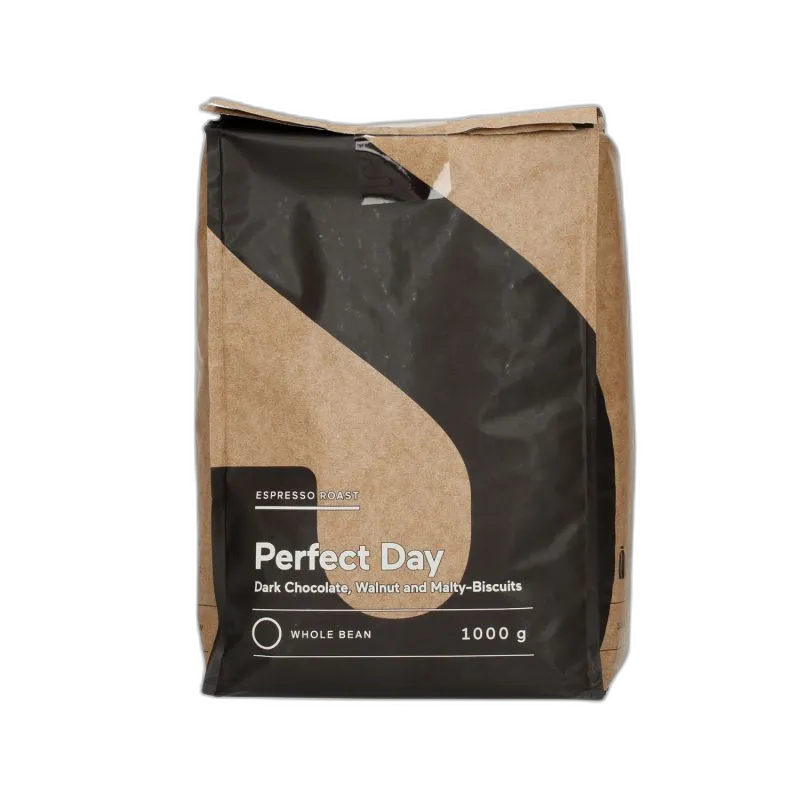Opakowanie kawy ziarnistej Perfect Day Espresso Roast o pojemności 1 kg. Nowoczesny design z brązowo-czarną kolorystyką. Intensywna kawa o wyrazistych nutach gorzkiej czekolady, orzecha włoskiego i słodowych ciastek. Doskonała do przygotowania espresso, idealna dla miłośników bogatych smaków. Całe ziarna, przeznaczone do świeżego mielenia i parzenia w ekspresach ciśnieniowych lub alternatywnych metodach.
