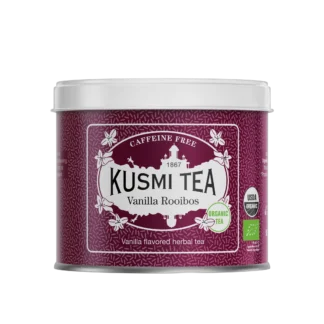 Fioletowa puszka herbaty Kusmi Tea Vanilla Rooibos z napisem "Caffeine Free" i "Organic Tea." Zawiera herbatę rooibos o smaku waniliowym, z certyfikatem USDA Organic oraz unijnym certyfikatem ekologicznym. Elegancki design z białymi zdobieniami i motywem wanilii.