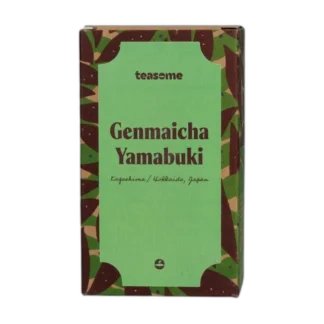 Japońska herbata zielona Teasome Genmaicha Yamabuki z regionów Kagoshima i Hokkaido została zapakowana w charakterystyczne zielono-brązowe pudełko z botanicznym wzorem. Zawiera mieszankę zielonej herbaty z prażonym ryżem, oferując łagodny, lekko orzechowy napar o tradycyjnym smaku.
