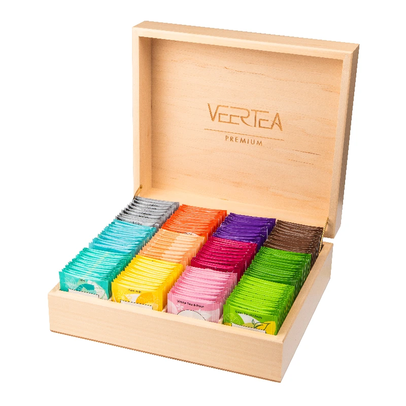 Obraz przedstawia elegancko zapakowany zestaw herbat premium VERTEA, umieszczony w drewnianym pudełku. Wewnątrz znajduje się mieszanka różnorodnych smaków herbat, idealnych do przygotowania aromatycznego naparu w domowym zaciszu.